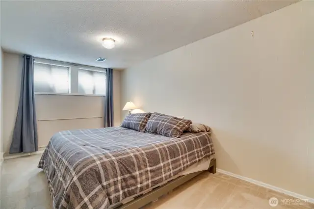The basement bedroom offers a cozy, stylish retreat ideal for guests, with a private vibe and modern touches that make it a welcoming haven.