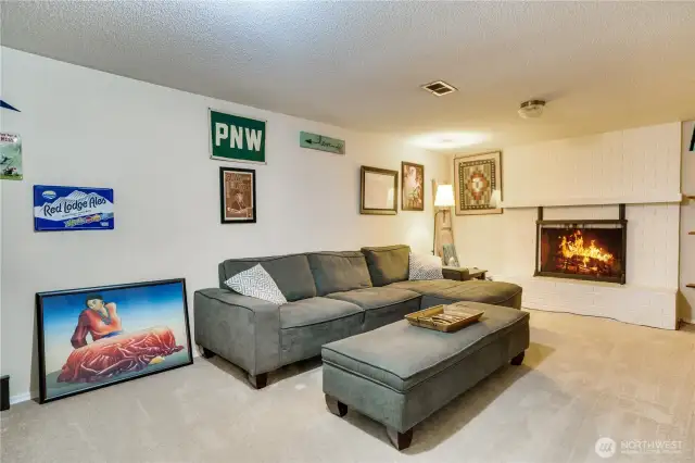 The cozy family room steals the show with a wood-burning fireplace setting the mood for chill nights, perfect for spinning vinyl or streaming movie marathons with friends.