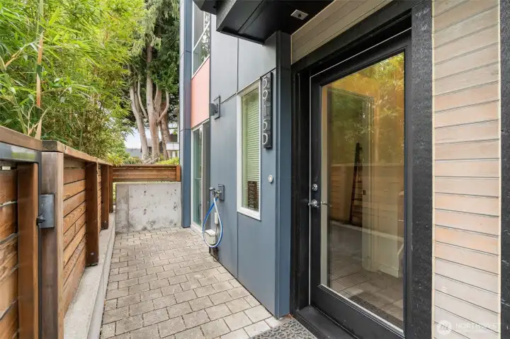 Lower level entrance on east side of building with gate and fence for privacy.