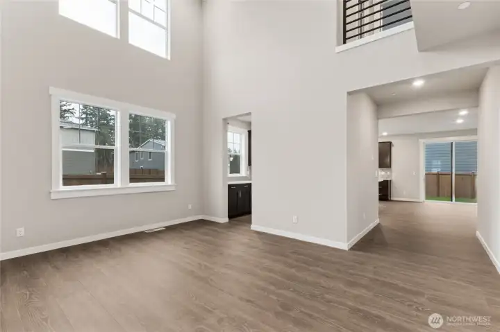 Dramatic two story vaulted ceilings in formal dining area with butler's pantry leading into kitchen.