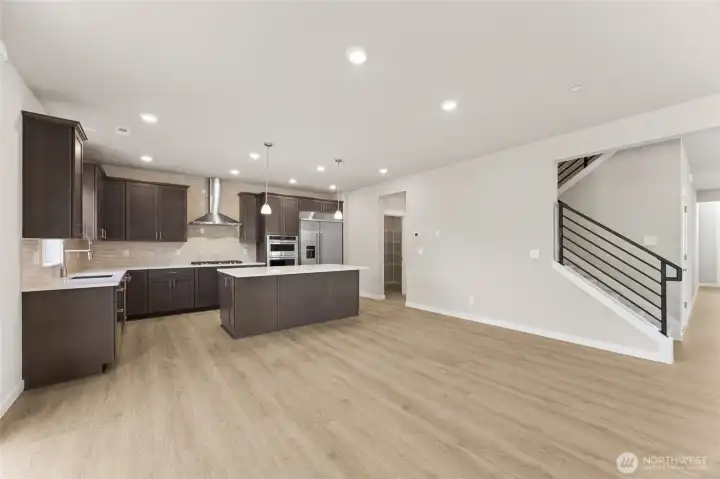 Well-appointed kitchen with gas cooktop, huge pantry adjacent to mud room just off the garage.  48" counter depth side-by-side refrigerator.  Plenty of space to entertain!   Showing a similar floorplan, the walk-through pantry leads to the 2-story formal dining room.