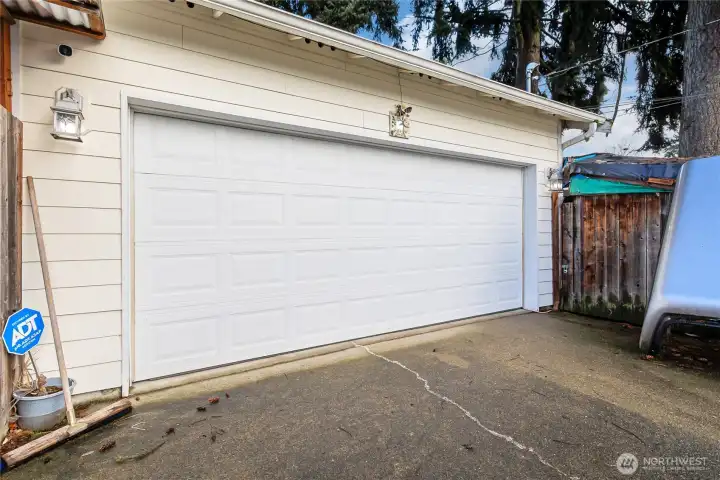 Nice two car garage with plenty of parking. The gate pictured opens to more storage and the storage shed in the back.