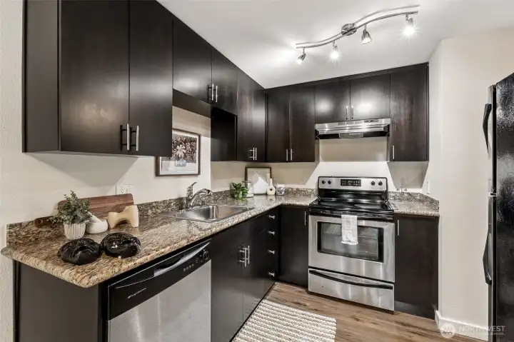 Granite counters, dark cabinets and stainless steel appliances are the highlights of this kitchen.