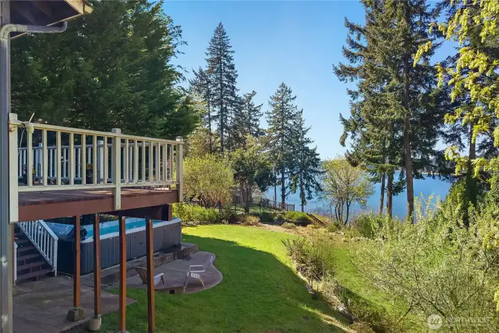 View from the deck overlooks the lawn, patio, swim spa, and waterfront setting. View from the deck overlooks the lawn, patio, swim spa, and waterfront setting.