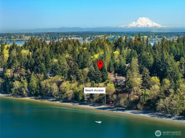 Elevated aerial captures shoreline, surrounding trees, and distant Mount Rainier. Elevated aerial captures shoreline, surrounding trees, and distant Mount Rainier.