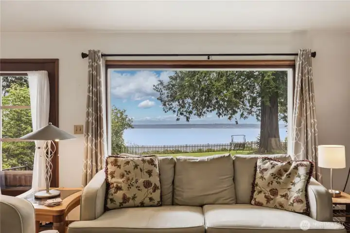The living room looks directly across the water towards Edmonds/Richmond Beach areas and the Cascades beyond.