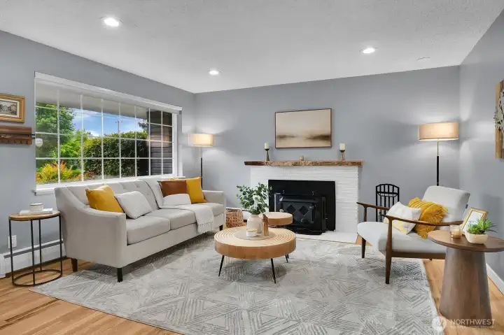 Beautifully staged living room with fireplace, oversized windows, and move-in ready charm in West Seattle real estate listing.