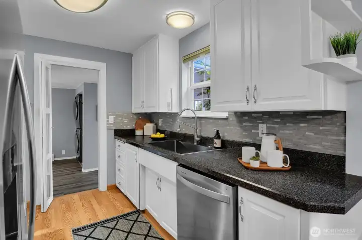 Bright updated kitchen featuring white cabinetry, modern finishes, and efficient workspace in move-in ready Seattle home.
