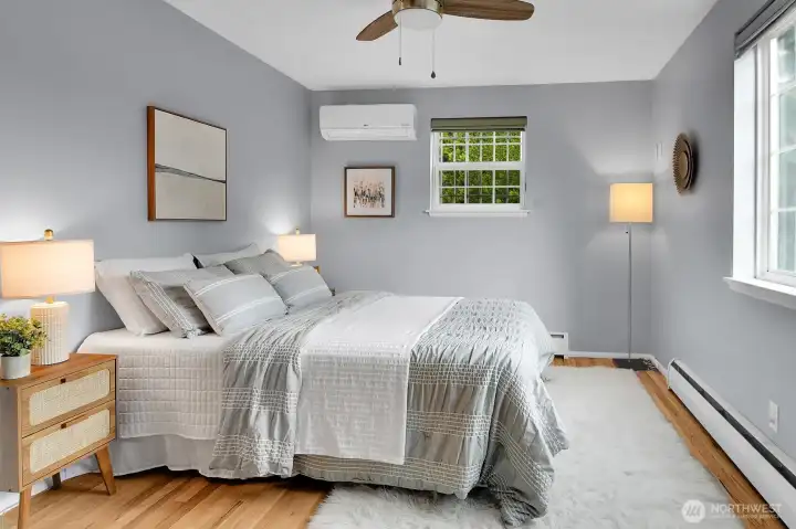 Peaceful primary bedroom with hardwood floors, soft natural light, and calming neutral tones in updated Seattle home.