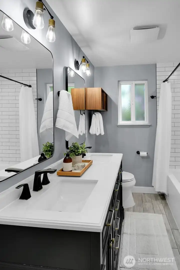 Updated bathroom with modern vanity, sleek lighting, and clean contemporary design in charming West Seattle rambler.