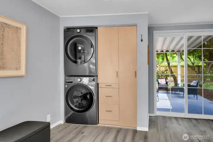 Convenient laundry area with stacked washer and dryer plus easy access to backyard and covered patio space.