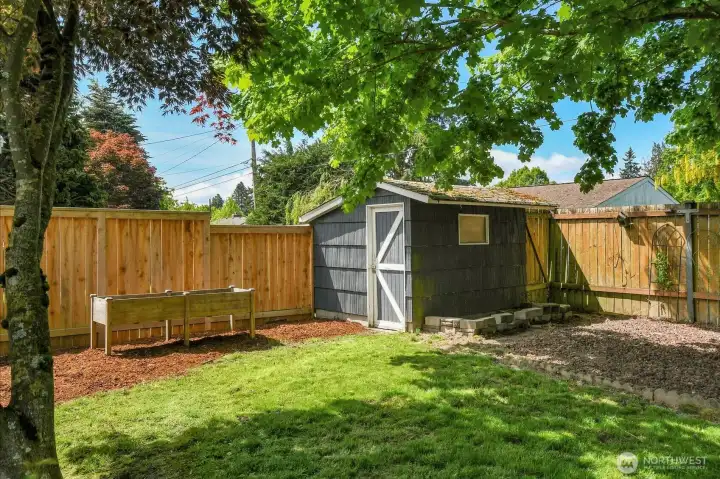Fully fenced backyard with storage shed, sunny lawn, and room for gardening, pets, or outdoor gatherings