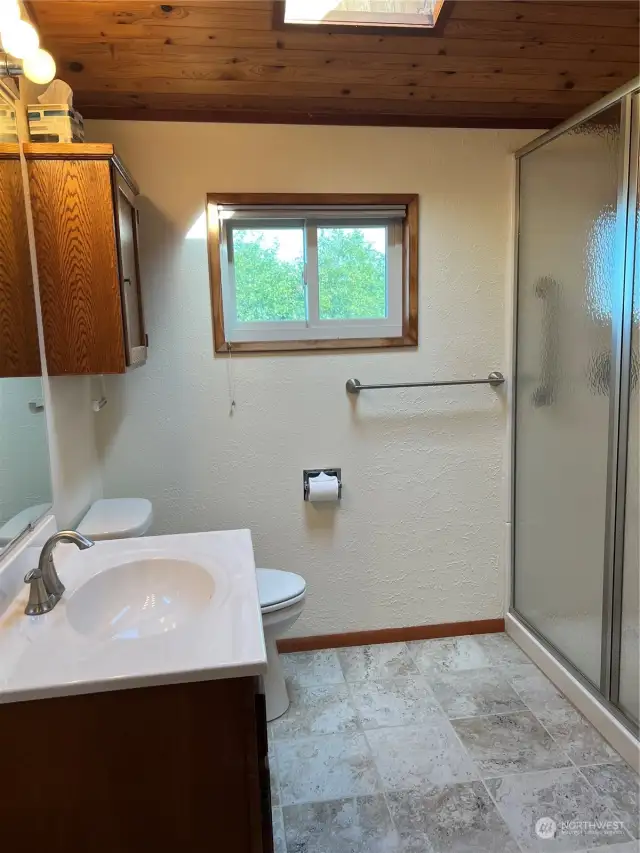 Completely remodeled primary bathroom with large shower and new tile floors.