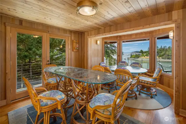 The dining area is set in a bay window to enjoy the views. French Doors lead out to the deck.