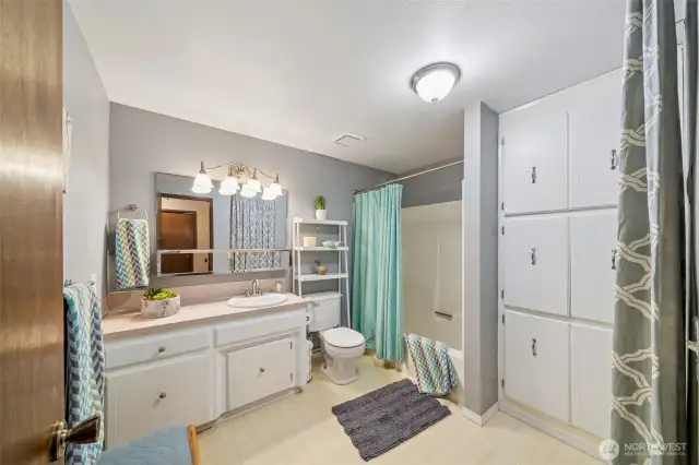 The extra large main bath features loads of linen storage space, a practical tub/shower surround, extra long vanity and even room for a bathroom bench.  Pretty white cabinets too.