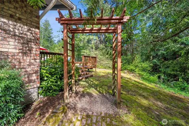Off the front entry, stroll through the charming arbor to the huge deck, lawns  and wooded areas of this .87 acre park-like grounds that surrounds the home.