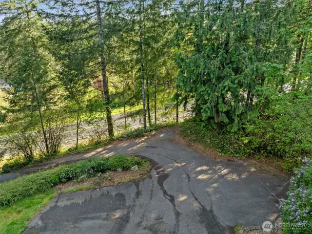 Looking down the driveway from the level parking area, extra parking for two cars or a back in spot for turning around is added to the driveway plan.  Third parking spot at the corner with gentle slope down to the road.