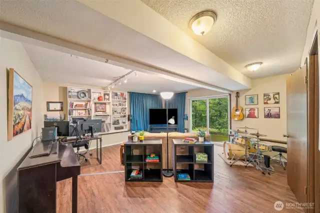 A few short steps down from the main entry, find the huge bonus space with easy-care wood laminate floors.  A true multi-purpose area for your office set up, big screen, or your band! Slider to patio too. Plumbed for wet bar.
