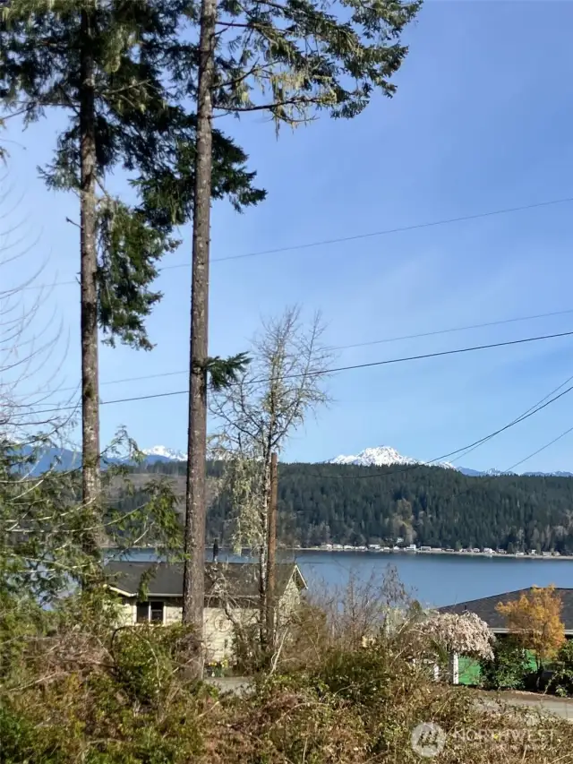 View from lot line looking over neighbors' roofs to Hood Canal and Olympic Mtns.