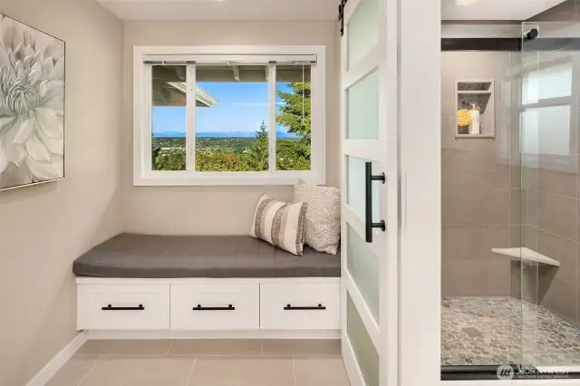 Changing/dressing area adjoins primary bedroom, with glass shower enclosure just steps away.