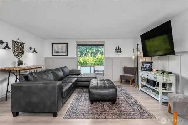 Bright upper-level living space featuring updated flooring, neutral tones, and a stylish board-and-batten accent wall.