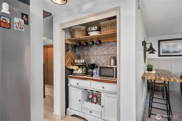 Convenient built-in beverage station with storage and decorative backsplash, perfect for a coffee or snack bar.