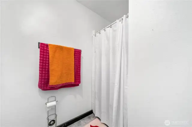 The lower-level bathroom includes a walk-in shower as well as Neutral walls and flooring create a simple backdrop, ready for personalization.