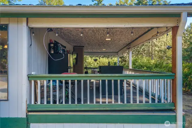 Inviting covered porch with railings and overhead lighting, offering a welcoming entry into the home. This spacious outdoor area is ideal for relaxing or entertaining, with easy access to both the front and back yards.