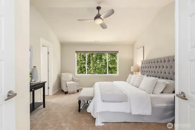 Spacious primary bedroom with vaulted ceilings and large window bringing in ample natural light.