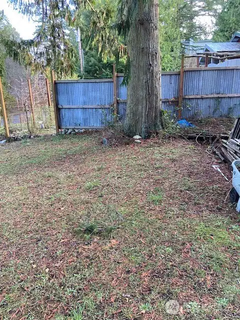 Looking towards the neighbor's fenced garden and eclectic fence & property.