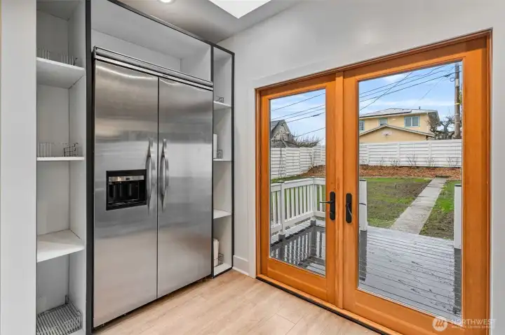 Viking stainless steel refrigerator and new Pella French doors open to new deck space and fully fenced level backyard