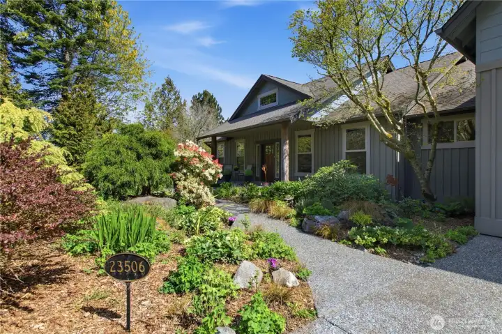 Front entry walkway adorned with lush flowering landscape