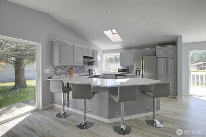 Light-filled, updated kitchen with modern finishes, generous counter space, ample cabinets, stainless steel appliances, and a a cheerful backsplash - perfect for everyday living and easy entertaining.