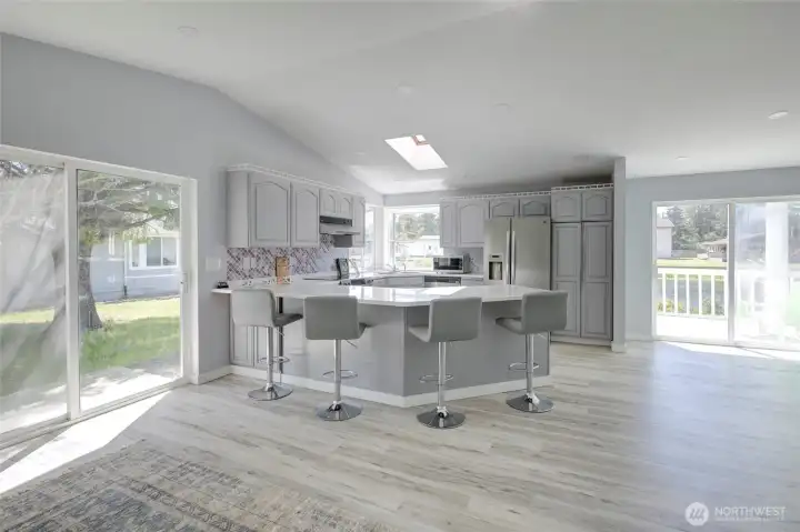 Light-filled, updated kitchen with modern finishes, generous counter space, ample cabinets, stainless steel appliances, and a a cheerful backsplash - perfect for everyday living and easy entertaining.