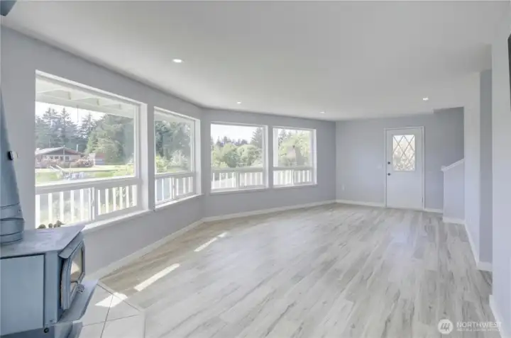 Bright and spacious main floor living area featuring updated flooring, soft neutral finishes, and an open, flowing layout