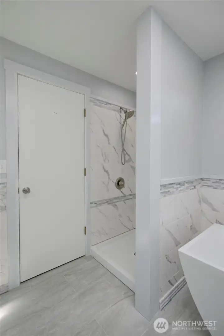 Light-filled primary bathroom with a soaking tub and separate walk-in shower—designed for both relaxation and everyday ease.