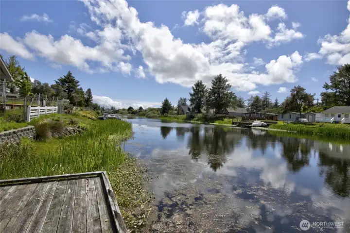 Step outside to your own private dock on a serene canal, where stunning water views, lush greenery, and a peaceful Pacific Northwest setting create the perfect backdrop for kayaking, fishing, or simply soaking in the beauty of waterfront living right in your backyard.