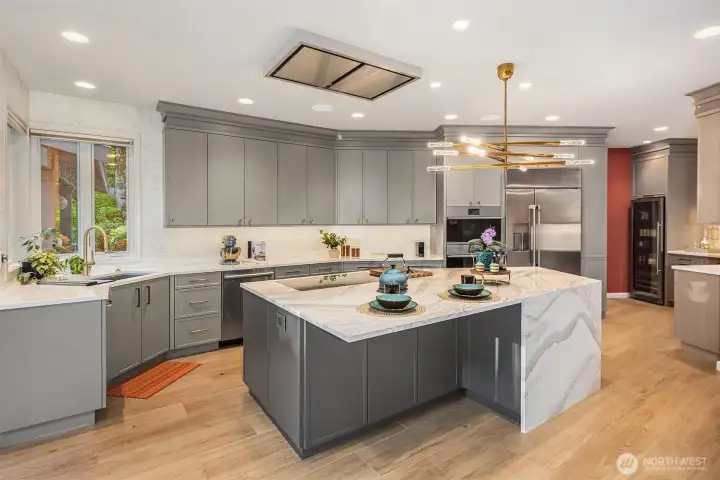 Enjoy the beautifully renovated kitchen featuring quartz slab countertops, heated porcelain floors, and custom cabinetry.