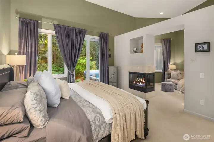 Luxurious main-floor primary suite with a cozy gas fireplace and comfortable seating area