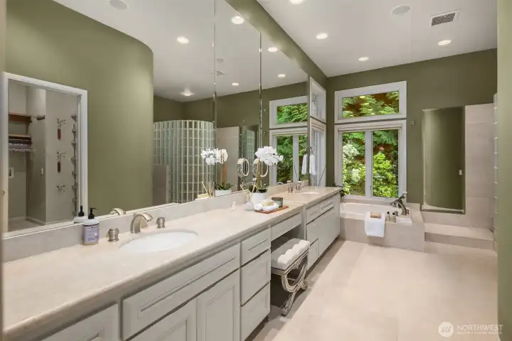 The spa-inspired primary bathroom showcases marble accents and a dedicated seating area