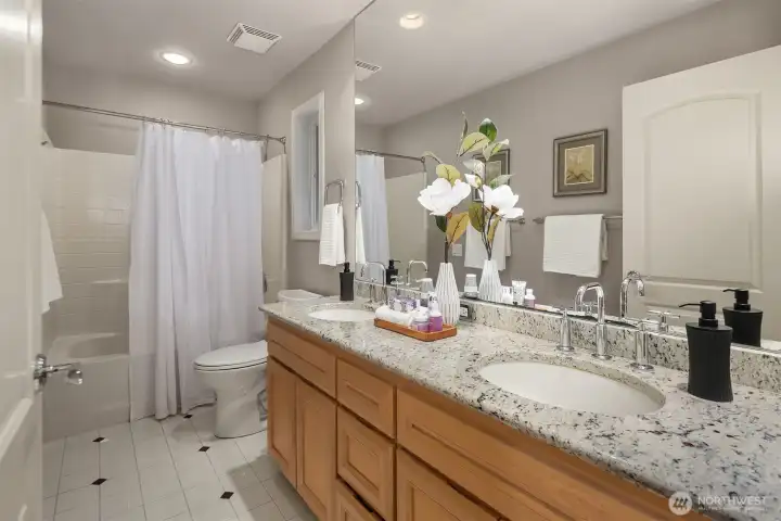 Upstairs, a well-appointed bathroom offers a convenient double sink vanity.