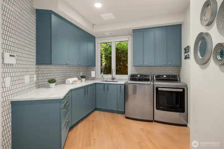Renovated laundry room with porcelain heated floors and a quartz slab countertop, combining style and functionality