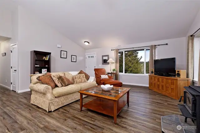 Living room with vaulted ceilings and wood burning fireplace..