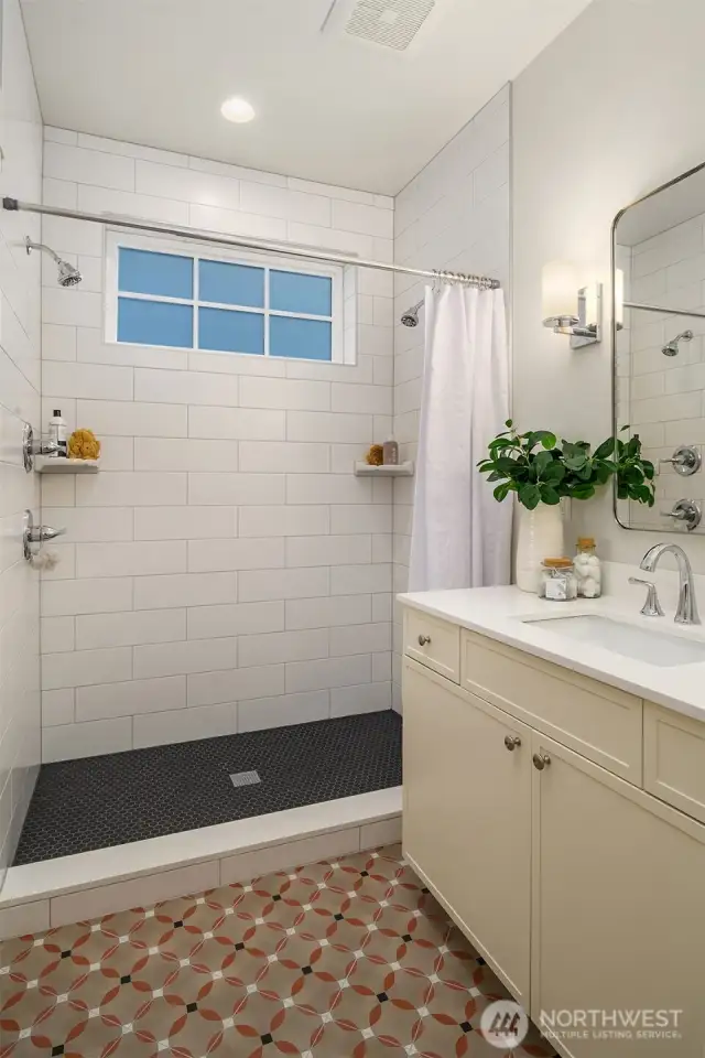The main floor bath is graced by patterned Italian tile heated flooring and a large custom walk in shower.