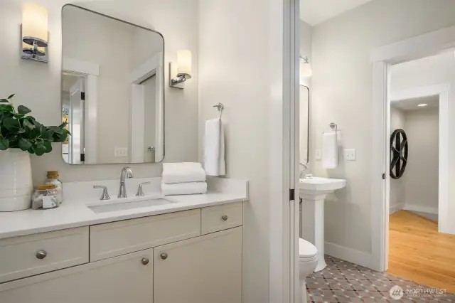 Custom painted cabinetry and pocket door that separates the bath spaces.