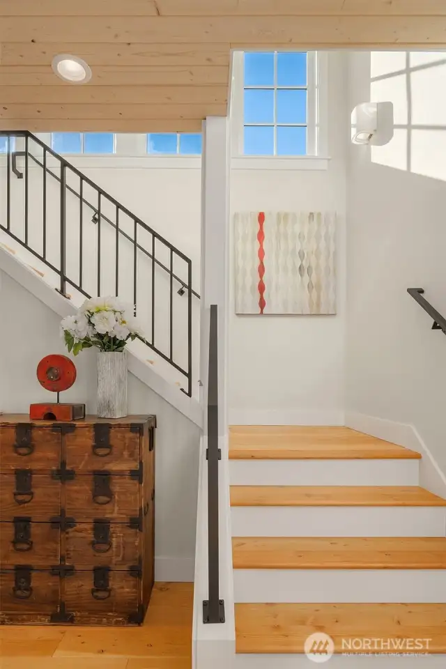 Stunning custom metal railings enhance the open entry stairway.