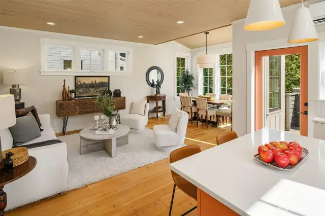 A warm paneled ceiling envelopes the gracious living and dining room that overlooks the lush gardens and woodland beyond.