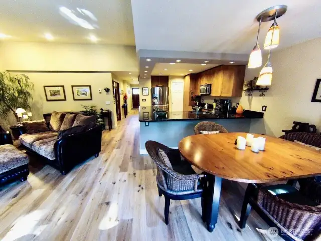 Inviting open-concept living, dining, and kitchen area that’s ideal for both entertaining and everyday living. The space features beautifully maintained hardwood floors, vaulted ceilings with recessed lighting, and a warm, neutral color palette that creates a welcoming ambiance.