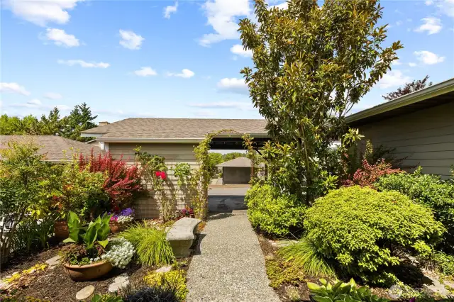 A beautifully landscaped walkway leads directly from the carport to the home’s welcoming front entrance.