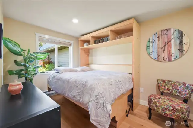 The built-in Murphy bed features integrated shelving above, ideal for displaying decorative pieces or storing essentials.